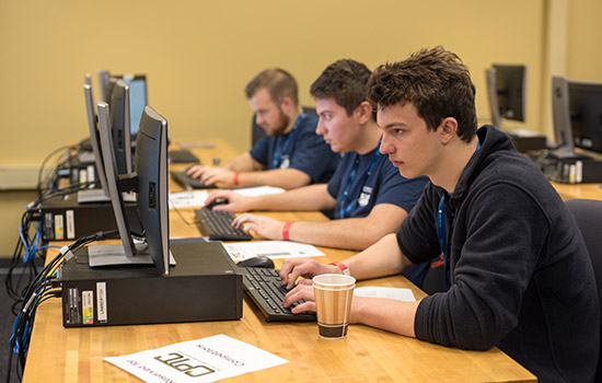 Three people focused on computer screens.