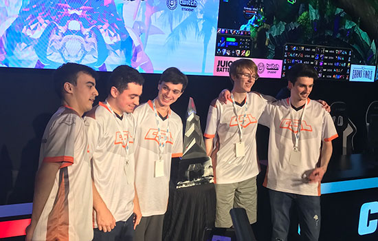 The winning RIT Dota 2 team poses for a photo with their trophy.