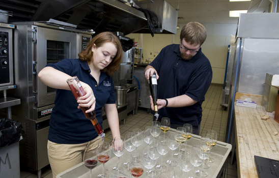 People pouring liquid into glasses