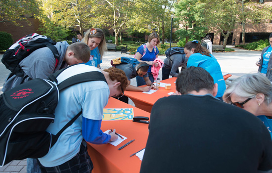 People signing papers at desk