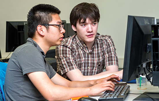 two people working on a computer.