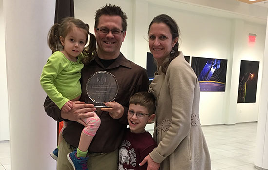 Eric Kunsman and family pose for a picture with award.