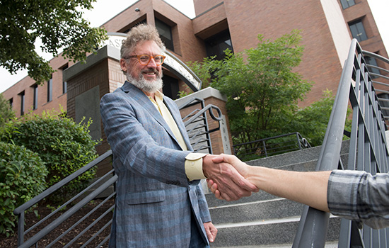 Two men shake hands.