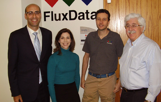 People posing in front of "Flux Data" logo