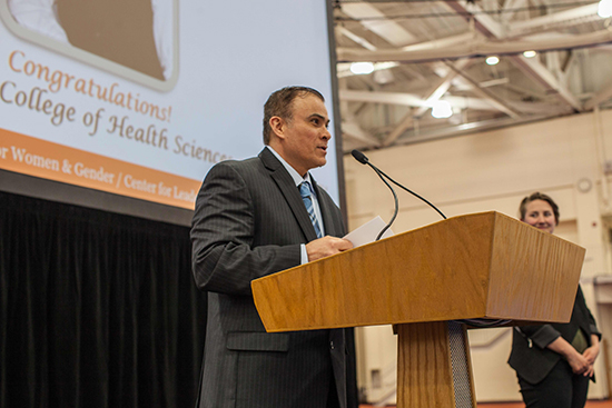 Hamad Ghazle standing at a podium accepting his award.