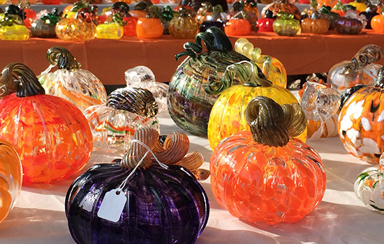 A patch of glass pumpkins on a table.