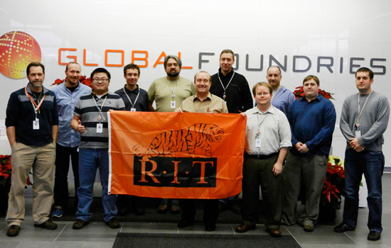 People posing with RIT flag infront of Global Foundries sign