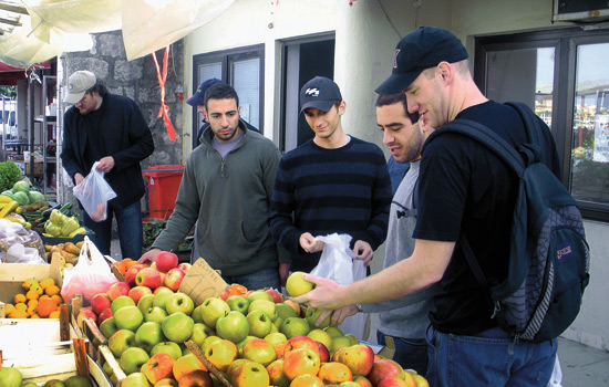 People looking at apples in market
