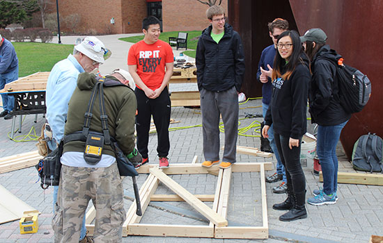 volunteers building framing for a house.