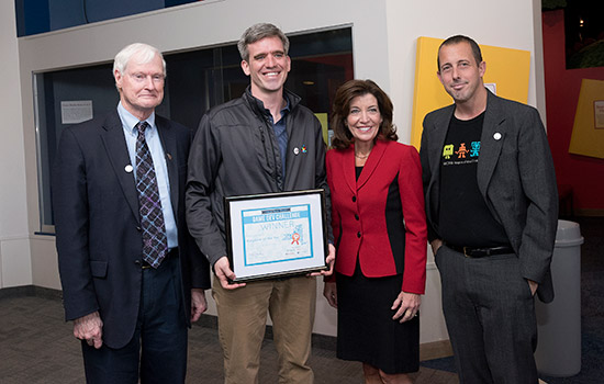 RIT President and professors posing with award