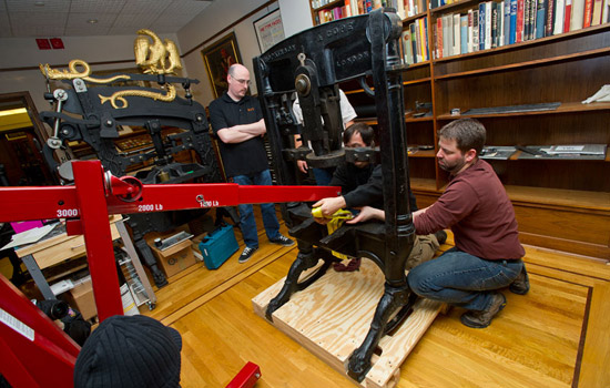 People working on a large letterpress machine.