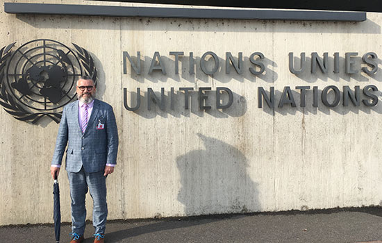 Peter Hauser standing in front of the United Nations sign.