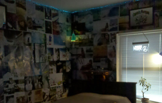 a dorm room with the walls covered in photos.