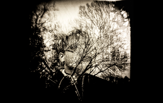 a photograph mixing in the image of a person and tree branches.