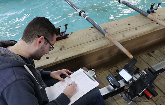 Person writing on a clipboard inside of a row boat.