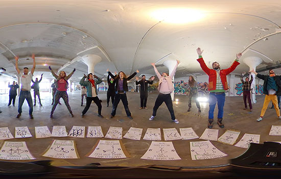 Students pose for 360 video with arms above their heads.