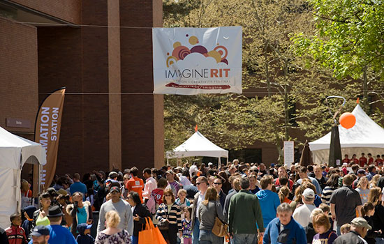 Crowd of people with a banner above saying "imagine RIT".