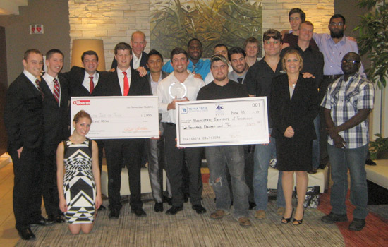 People gathered posing with two checks
