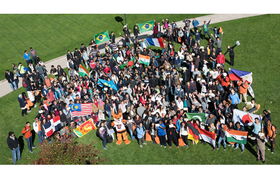 People gathered for picture with numerous flags