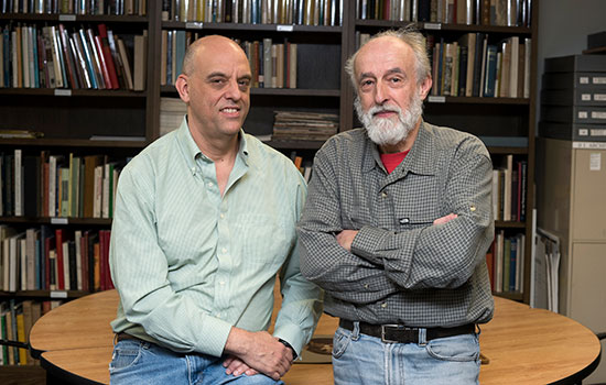 Daniel Burge, left, and Jean-Louis Bigourdan in button down shirts standing in front on books.