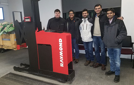 The industrial engineering graduate students stand together for a photo at the Raymond Corp. office.