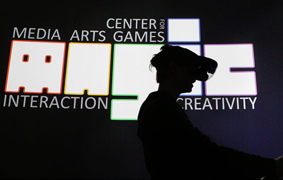 Student with VR headset, in front of the MAGIC logo.