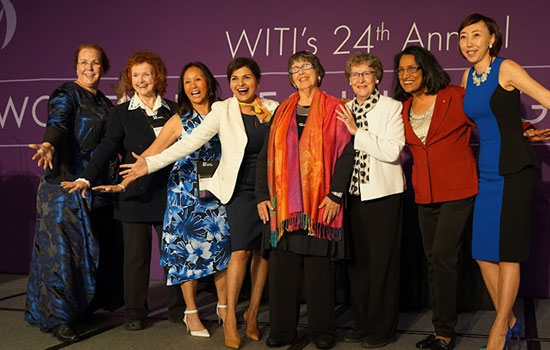 Santosh Kurinec and other honorees excitedly pose for a photo, all of them smiling wide and holding their arms out in triumph.