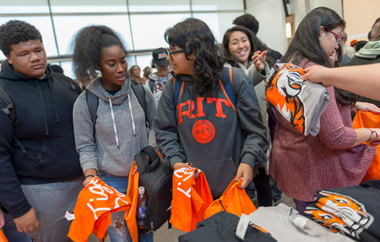 group of students being handed t shirts.