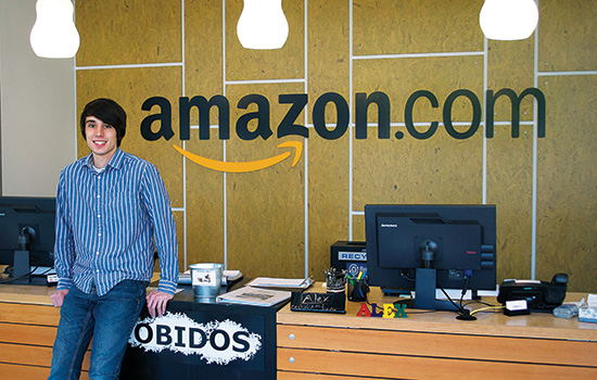 Person posing in front of amazon.com logo
