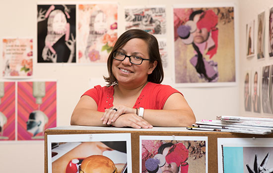 woman posing with prints of her photography.