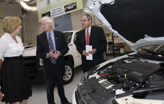 RIT president and Professors observing a car engine