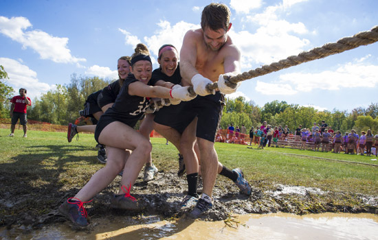 People participating in mud tug