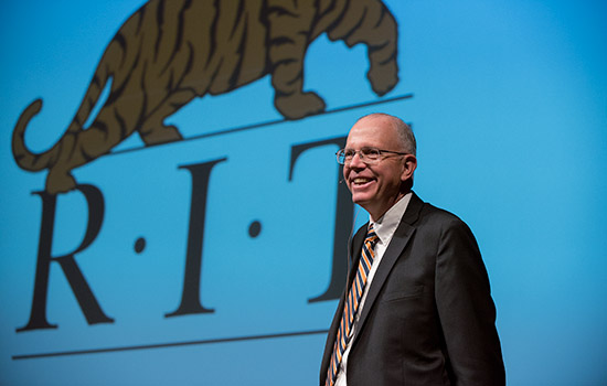 Picture of President Munson next to RIT logo