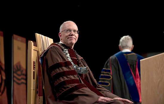 President Munson sitting on chair on stage