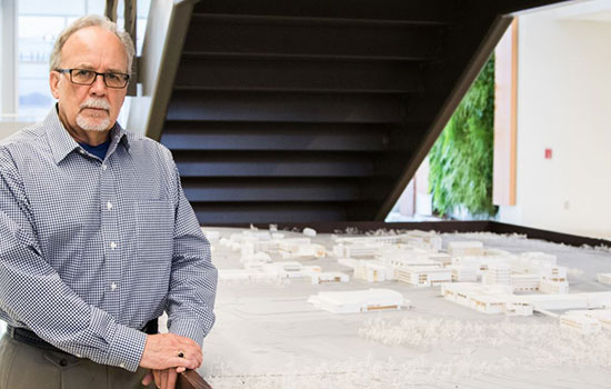 Dennis A. Andrejko poses next to architecture work.