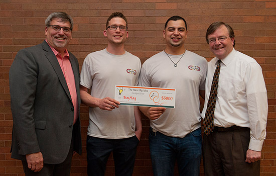 Professor and Students posing with check