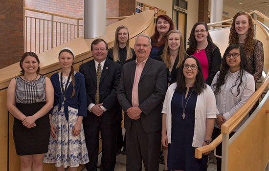 Students pose for a photo on a staircase with president Gerry Buckley.