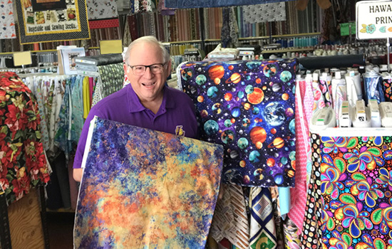 Richard Potter surrounded by different fabrics.