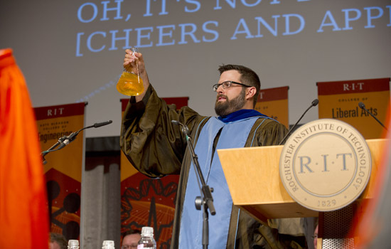 Professor holding jar on stage