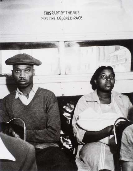 Old photo of two people sitting in segregated bus