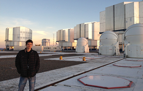 Person posing in field with multiple observatories
