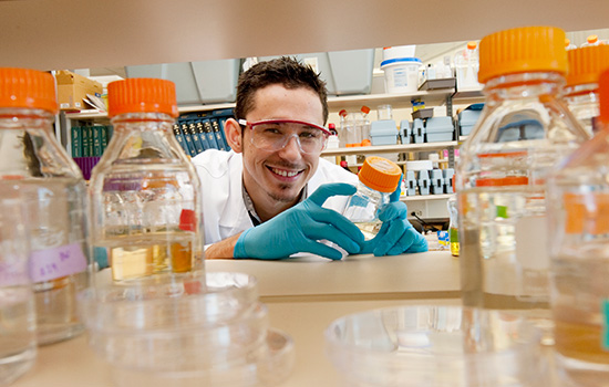 Scientist posing with bottle in lab