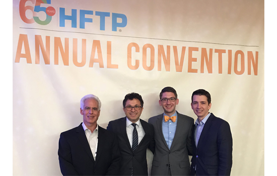 Linden Pohland poses for a photo with three other men at the HFTP Convention.