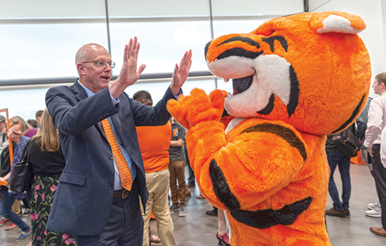 President Munson high-fives tiger mascot.