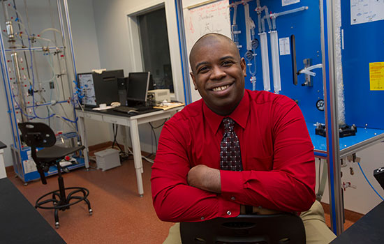 Professor, Reginald Rogers posing for picture in classroom