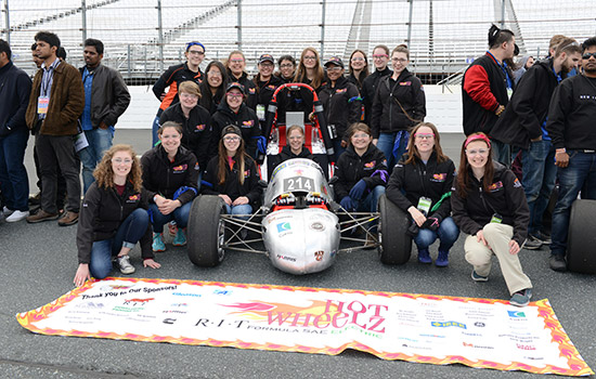 Team posing near formula car