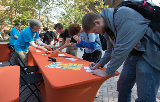 People signing cards at a table