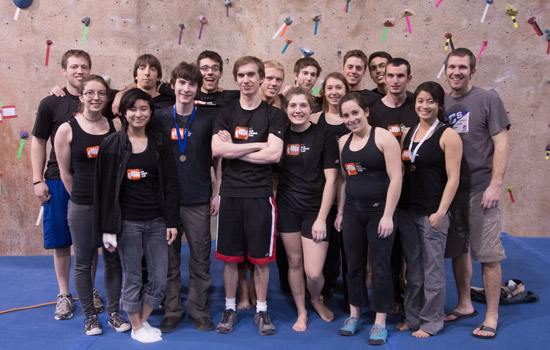 People posing in front of rock wall