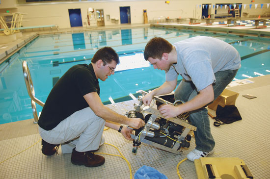 Students Working on Robot next to pool