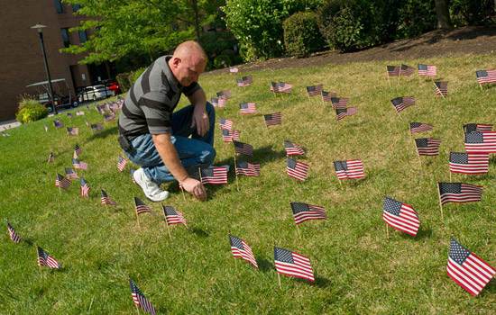 Person planting flags on field